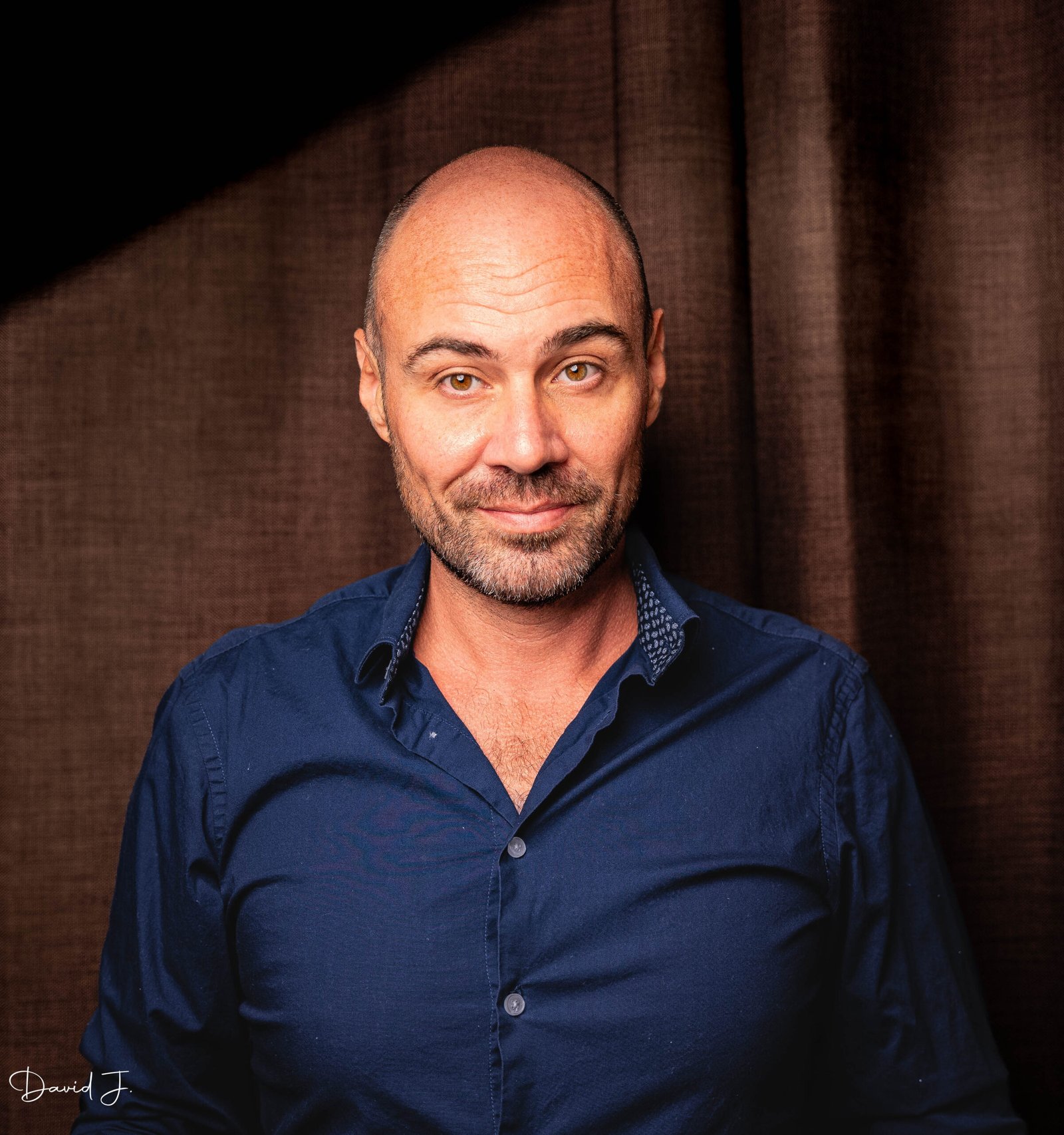 Portrait d’un homme en chemise sur un fond sombre, en studio