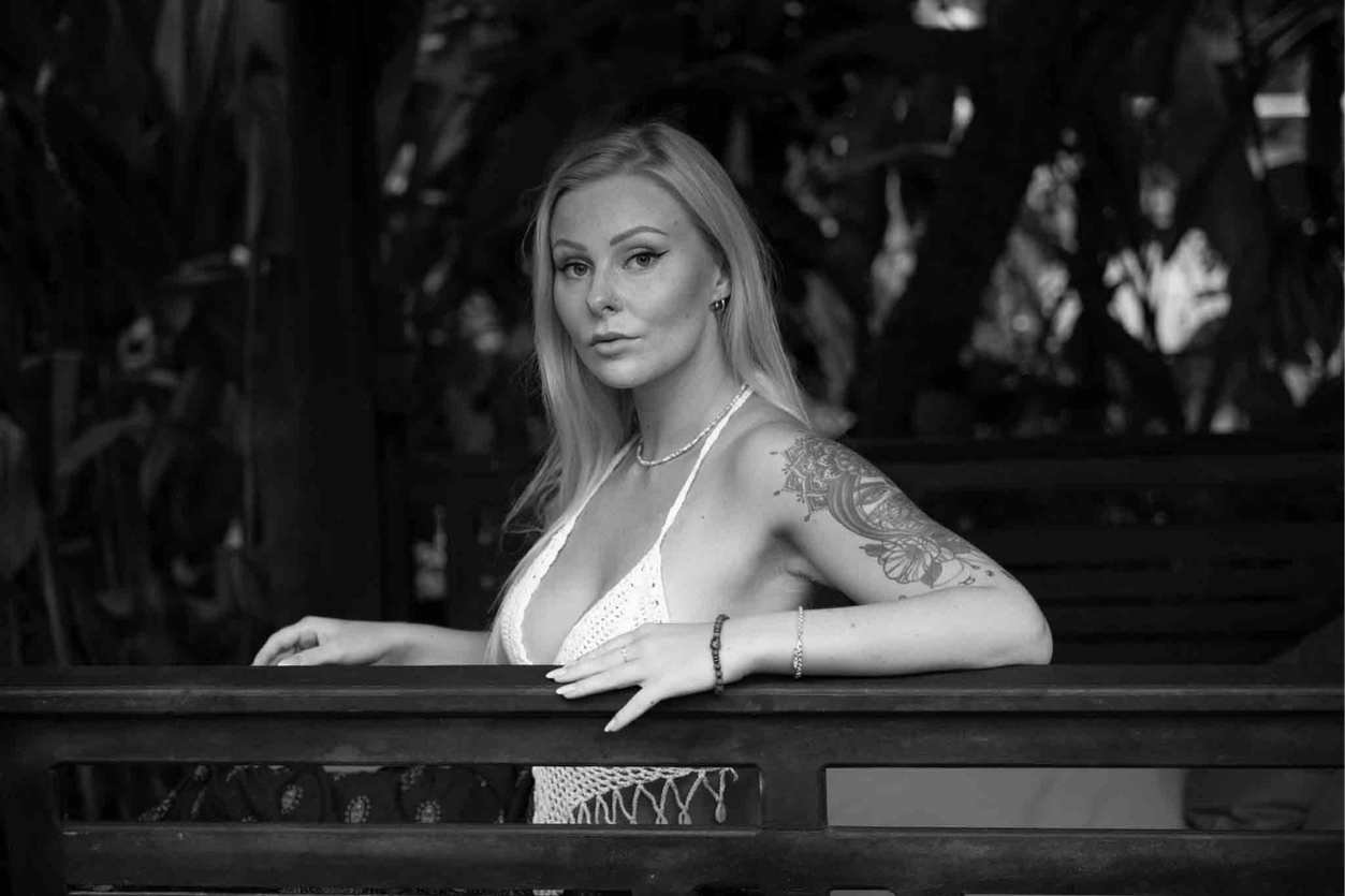 Portrait en noir et blanc d’une femme assise sur un banc, à Nice